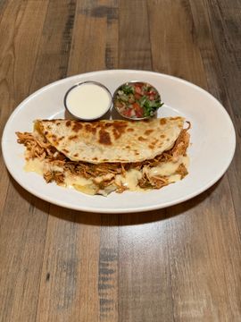 Cheesy quesadilla served with condiments