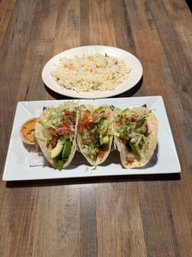 Tacos with rice on wooden table