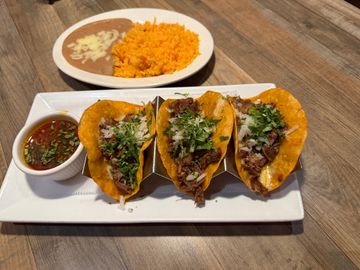 Tacos served with beans and rice