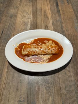 Enchilada with sauce on white plate