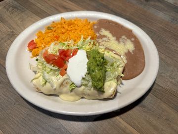 Burrito topped with guacamole and cream