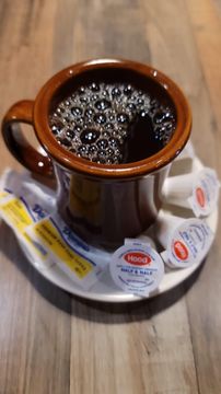 Hot coffee in rustic mug on table