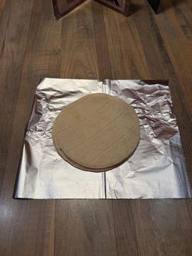 Round wooden board on foil sheet