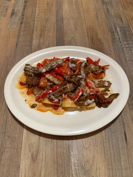 Beef and peppers on a white plate.