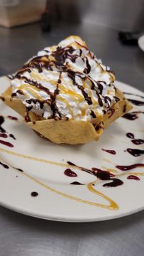 Waffle bowl dessert with cream and sauces