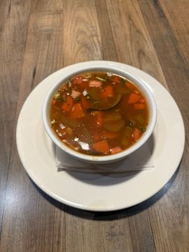Bowl of soup with carrots and herbs