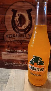 Orange soda bottle beside restaurant sign