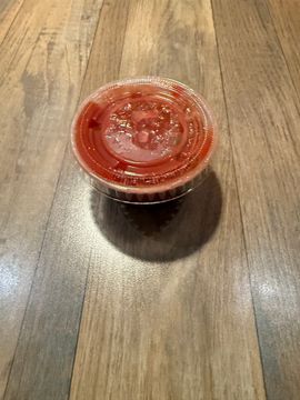 Condiment cup with red sauce