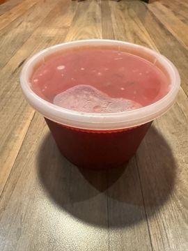 Plastic tub filled with red liquid.