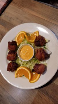Appetizer with dipping sauce and orange garnish