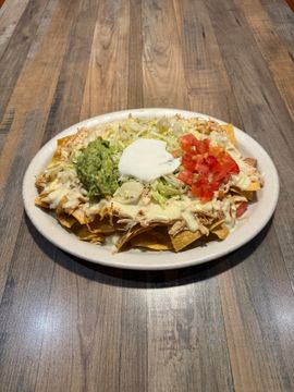 Loaded nachos with toppings on plate