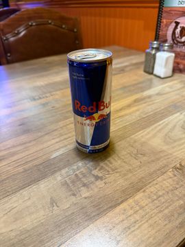 Red Bull can on wooden table