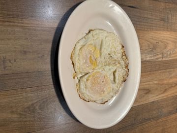 Sunny-side-up eggs on wooden table