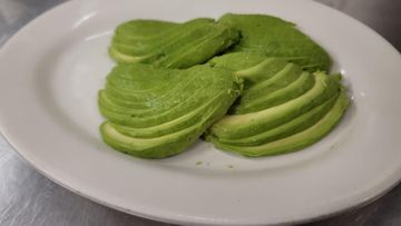 Sliced avocado on white plate