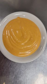 Creamy orange sauce in white bowl
