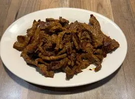 Seasoned beef strips on a white plate