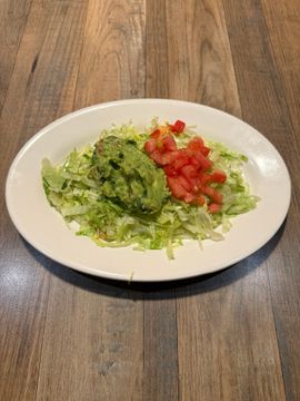 Guacamole and tomatoes on shredded lettuce
