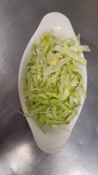 Shredded lettuce in white dish