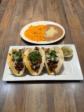 Tacos with rice and beans on table