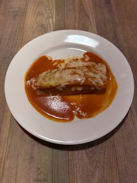 Cheesy enchilada served with sauce
