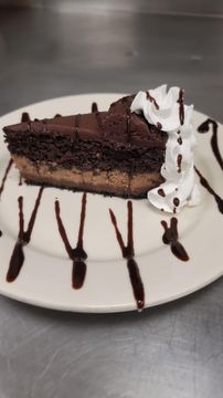Chocolate cake slice with whipped cream and drizzle